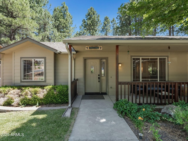 490 E Twelve Oaks Dr, Flagstaff, AZ 86005 - view of exterior entry with roof with shingles and covered porch