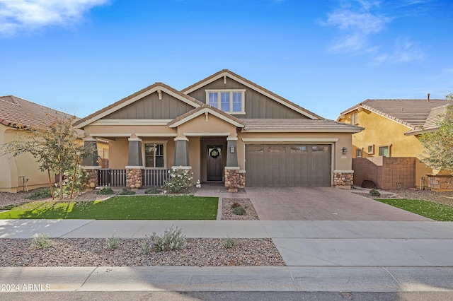 craftsman inspired home featuring covered porch and a garage