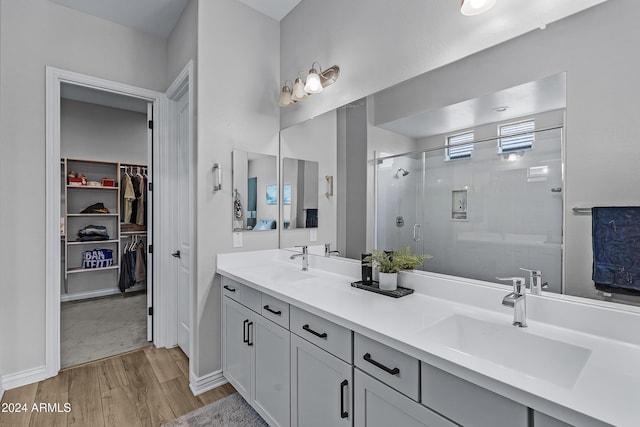 bathroom with vanity, hardwood / wood-style flooring, and a shower with door