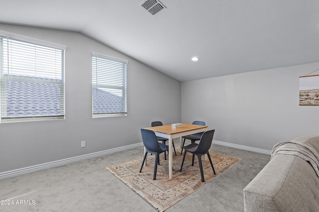 dining room with carpet flooring and vaulted ceiling