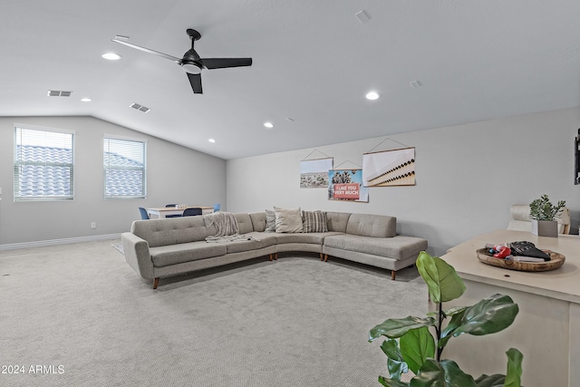 carpeted living room with ceiling fan and vaulted ceiling