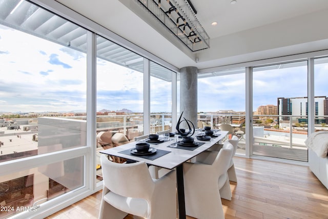 dining space featuring light wood-style flooring, healthy amount of natural light, recessed lighting, and a view of city