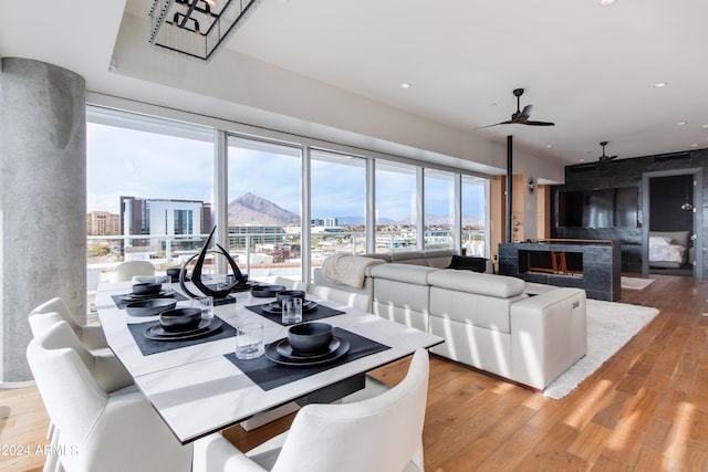 dining space with a view of city, wood finished floors, ceiling fan, and recessed lighting