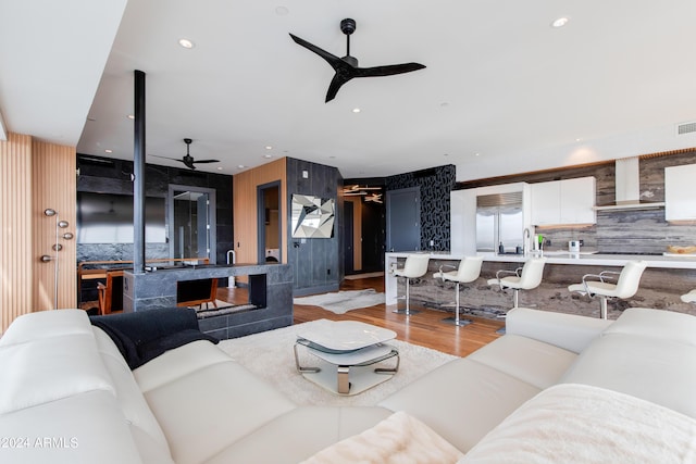 living area with ceiling fan, light wood-style flooring, and recessed lighting