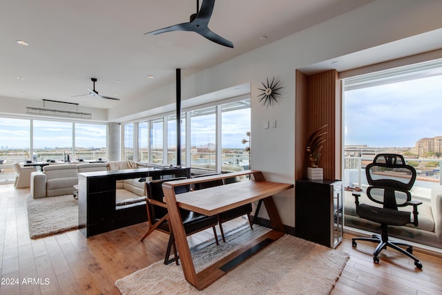 dining space with a ceiling fan, light wood-style floors, a city view, plenty of natural light, and recessed lighting