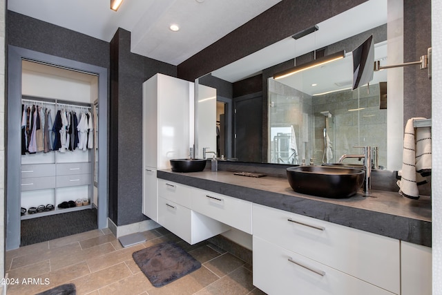 bathroom featuring a stall shower, a spacious closet, and vanity