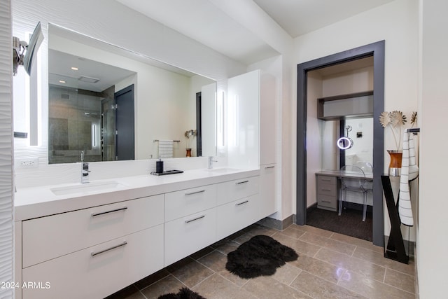 bathroom featuring a shower stall, double vanity, and baseboards