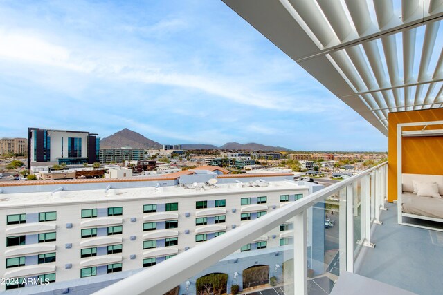 balcony with a mountain view and a view of city