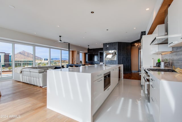 kitchen featuring a sink, open floor plan, white cabinetry, a ceiling fan, and recessed lighting