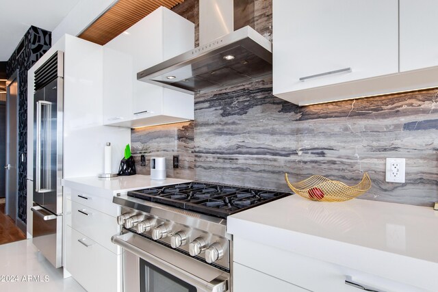 kitchen with high quality appliances, wall chimney exhaust hood, modern cabinets, white cabinets, and decorative backsplash