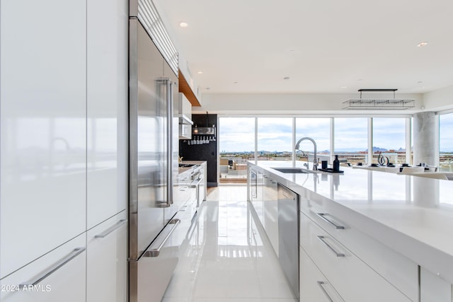 kitchen with a sink, modern cabinets, appliances with stainless steel finishes, recessed lighting, and healthy amount of natural light