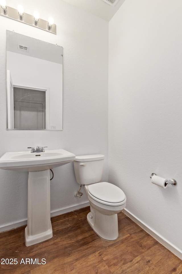 bathroom with visible vents, baseboards, toilet, and wood finished floors