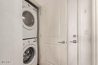 clothes washing area with laundry area and stacked washer and clothes dryer