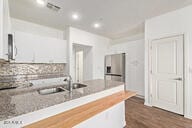 kitchen featuring backsplash, a peninsula, light countertops, and a sink