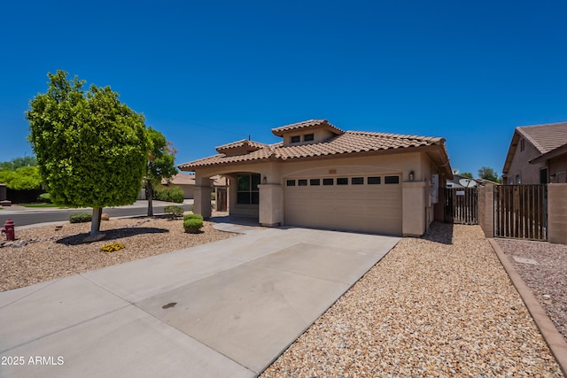 9074 W Runion Dr, Peoria, AZ 85382 - mediterranean / spanish home featuring stucco siding, a tiled roof, a gate, a garage, and concrete driveway
