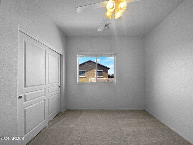 unfurnished bedroom with carpet flooring, a closet, and ceiling fan