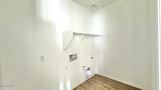 clothes washing area featuring hookup for a washing machine, light hardwood / wood-style flooring, and hookup for an electric dryer