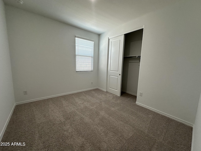 unfurnished bedroom featuring carpet floors, a closet, and baseboards