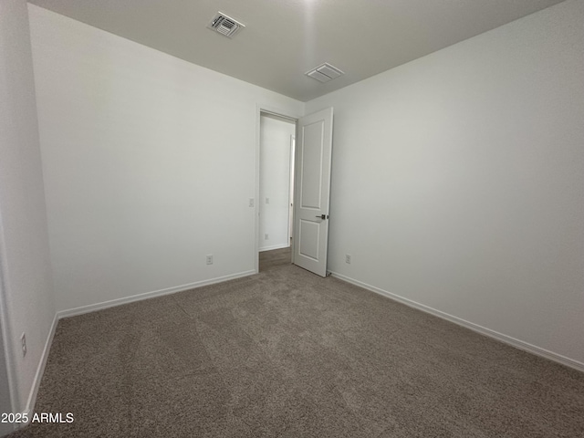 unfurnished room with baseboards, visible vents, and carpet flooring