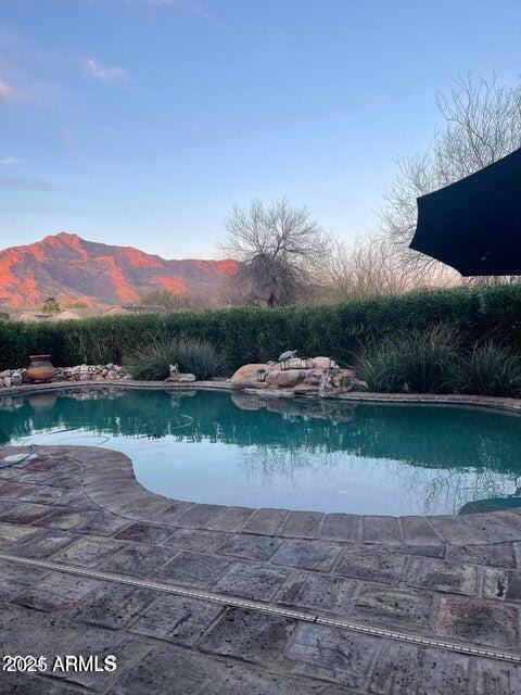 view of swimming pool with a mountain view