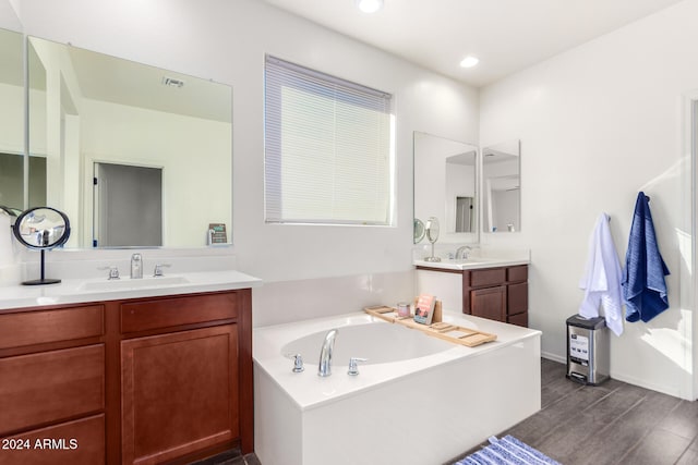 bathroom with vanity, a tub to relax in, and hardwood / wood-style floors