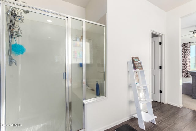 bathroom with ceiling fan, wood-type flooring, and a shower with shower door