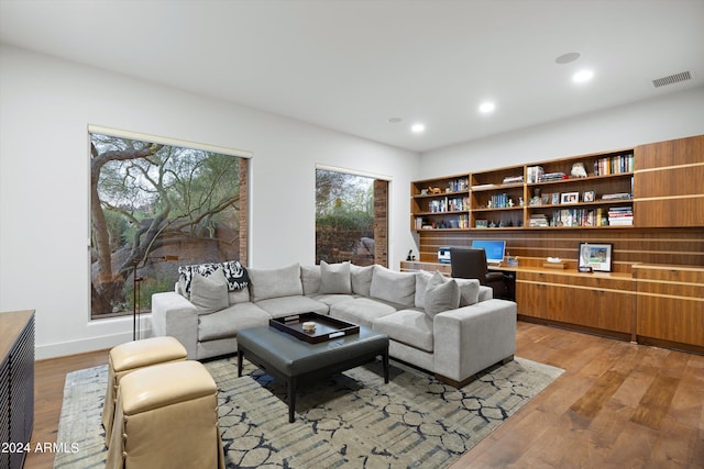 living room with built in desk and hardwood / wood-style flooring