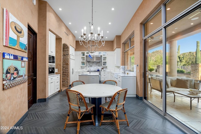 dining space featuring dark parquet flooring and an inviting chandelier