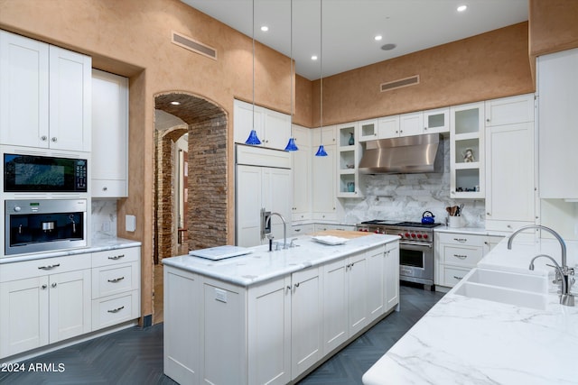 kitchen with dark parquet floors, white cabinets, and built in appliances