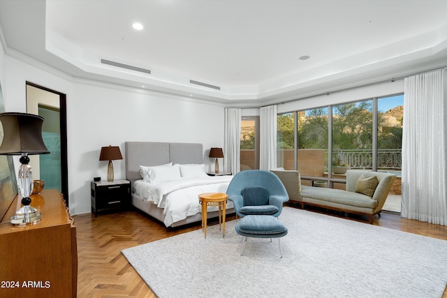 bedroom with a raised ceiling and parquet flooring