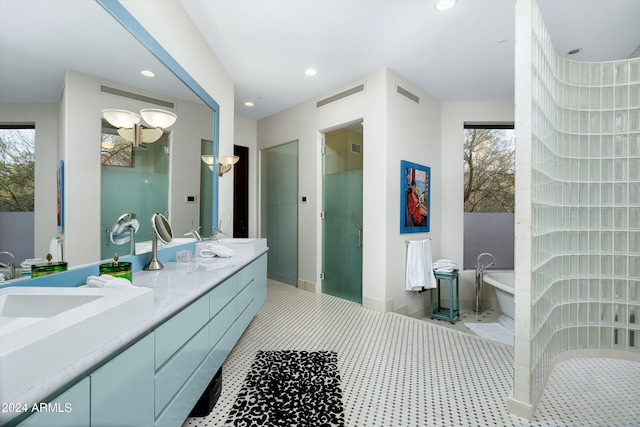 bathroom featuring vanity with extensive cabinet space, a bath, double sink, and tile flooring