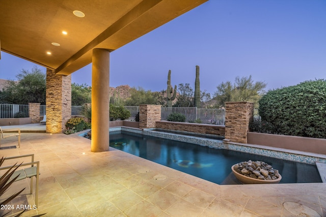 pool at dusk featuring a patio area