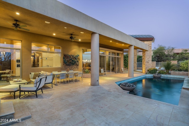 pool at dusk featuring a patio and ceiling fan