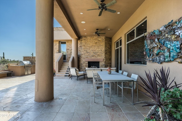 view of terrace with ceiling fan and an outdoor kitchen