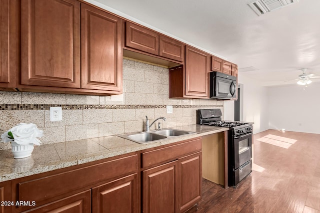 kitchen featuring tasteful backsplash, ceiling fan, dark wood-type flooring, sink, and black appliances