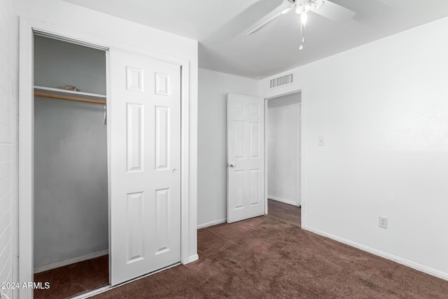 unfurnished bedroom featuring dark colored carpet, ceiling fan, and a closet