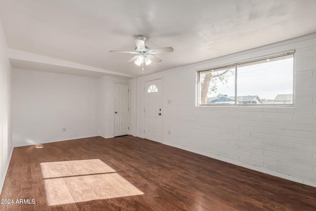 entrance foyer with dark hardwood / wood-style floors, ceiling fan, and brick wall