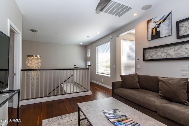 living room featuring a chandelier and dark hardwood / wood-style flooring