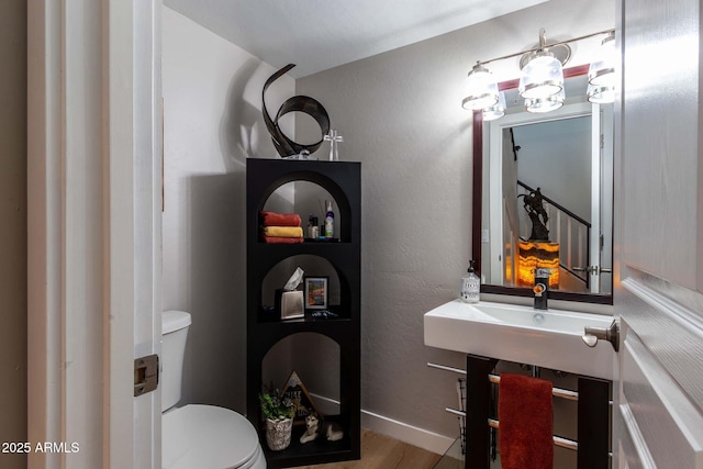 bathroom featuring hardwood / wood-style flooring and toilet