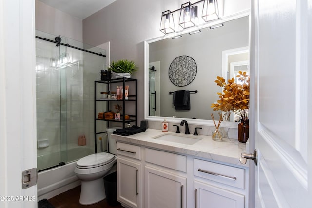 full bathroom featuring shower / bath combination with glass door, vanity, and toilet