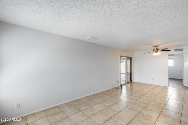 5504 N 69th Ave, Glendale, AZ 85303 - spare room featuring plenty of natural light, a textured ceiling, a ceiling fan, and light tile patterned floors