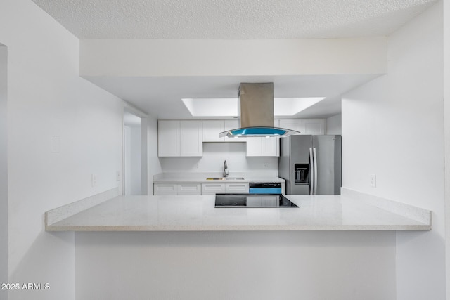 5504 N 69th Ave, Glendale, AZ 85303 - kitchen featuring stainless steel fridge, a peninsula, island range hood, a sink, and a textured ceiling