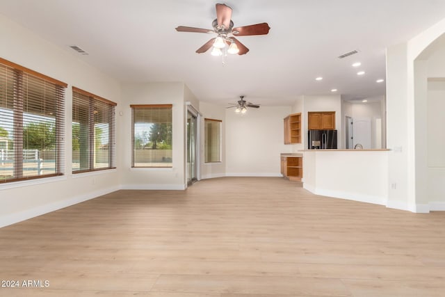 unfurnished living room featuring light wood-type flooring and ceiling fan