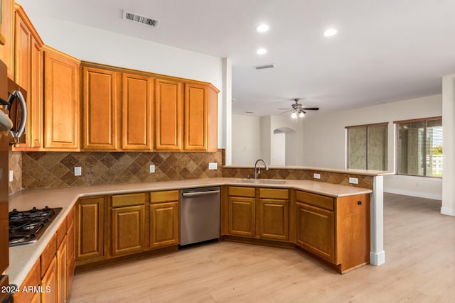 kitchen with kitchen peninsula, light hardwood / wood-style floors, ceiling fan, and sink