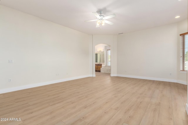 spare room featuring ceiling fan, a healthy amount of sunlight, and light hardwood / wood-style flooring