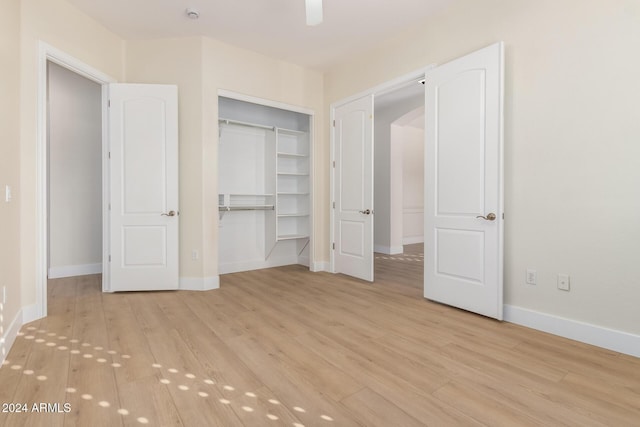 unfurnished bedroom with a closet, light hardwood / wood-style flooring, and ceiling fan