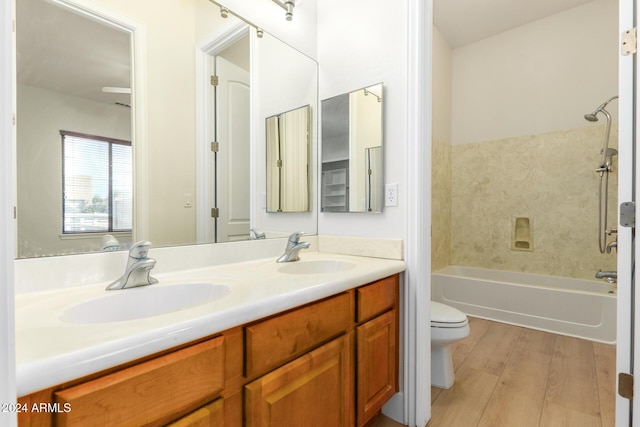 full bathroom with shower / bathing tub combination, vanity, wood-type flooring, and toilet