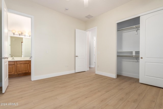 unfurnished bedroom with ensuite bath, a closet, light hardwood / wood-style flooring, and ceiling fan