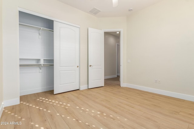 unfurnished bedroom with ceiling fan, light hardwood / wood-style flooring, and a closet