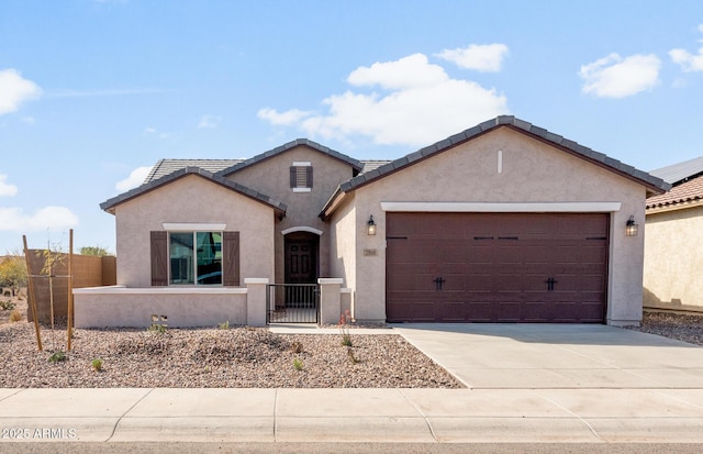 single story home featuring driveway, a garage, a fenced front yard, a tiled roof, and stucco siding